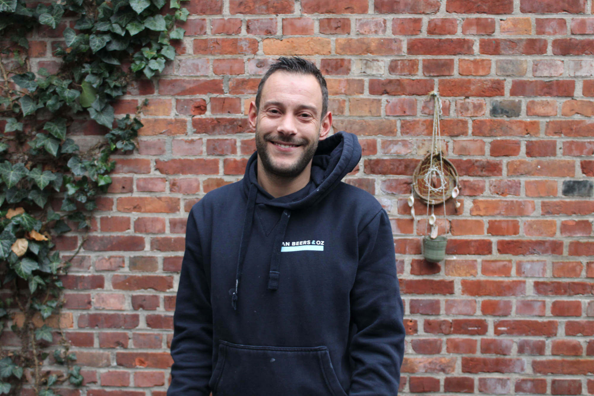 Loodgieter poseert voor bakstenen muur