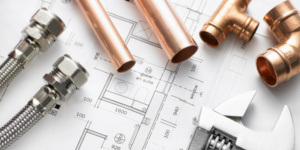 Leidingen en gereedschap liggen op een bouwtekening