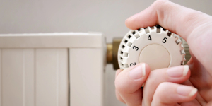 Hand draait aan knop radiator
